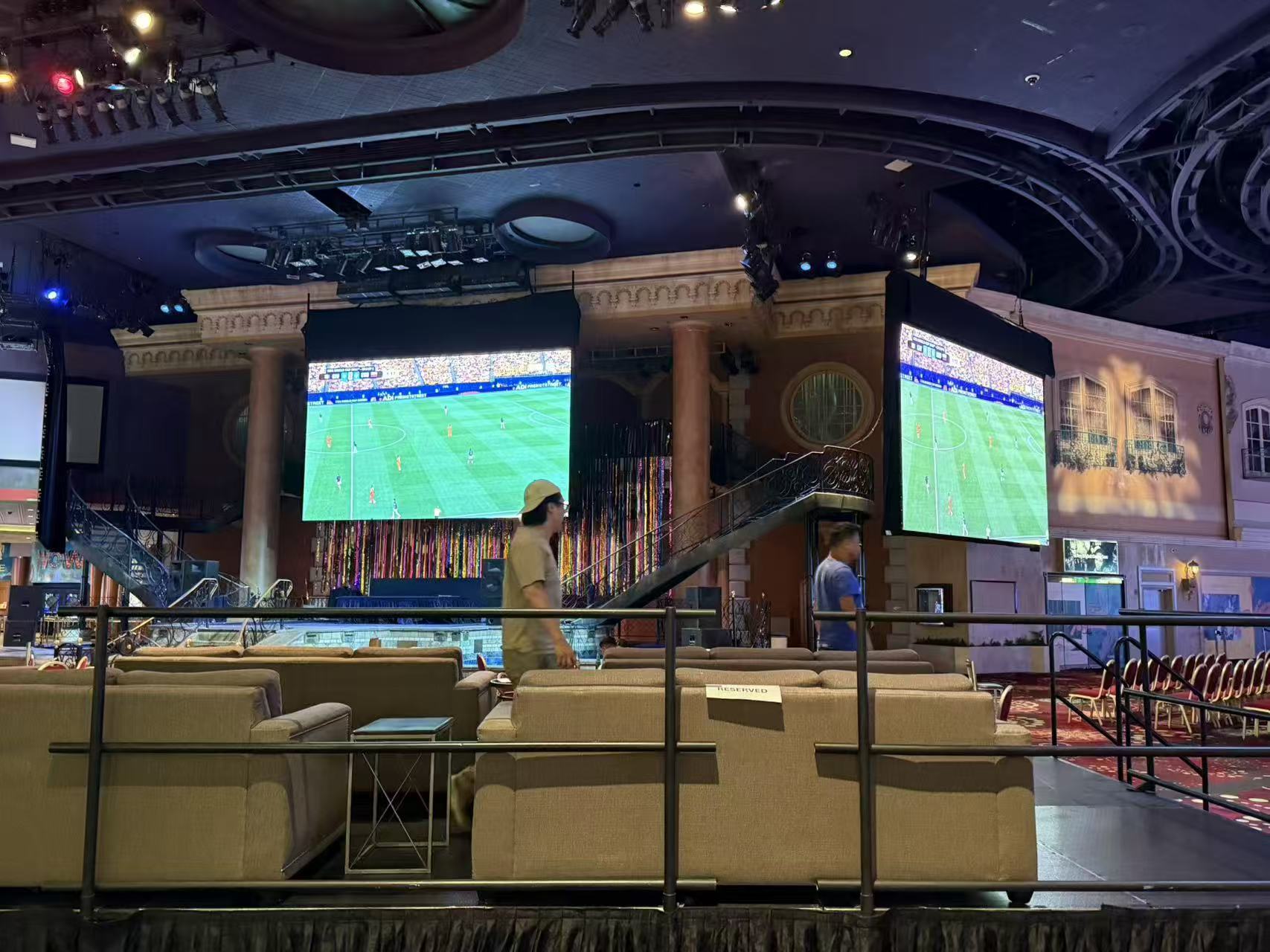 Two elevated LED screens in an indoor entertainment venue